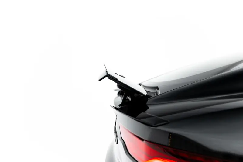 pol_po_Spoiler-Cap-Jaguar-F-Type-X152-Facelift-2-23971_3webp - OPSHOLDERS Close-up of the rear end of a white car, showing the red tail light and rear wiper against a white background.