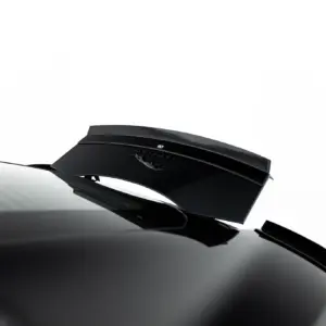 Close-up of a glossy black sports car hood with a raised rear wing and a Lamborghini emblem on the side.