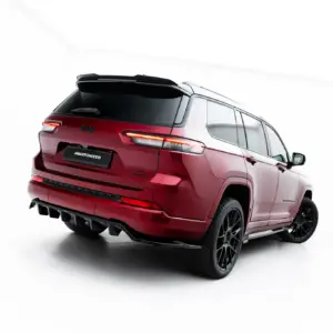 Rear three-quarter view of a red Jeep SUV in a studio, showing bold taillights and a black roof rack, with a dark license plate reading '#MAXTONIZED'.