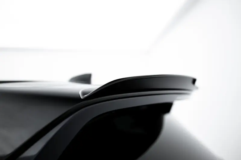 Close-up of a car roof with a small shark-fin antenna on top.