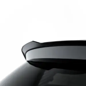 Close-up of a glossy black car body with smooth curved edges and reflected light.