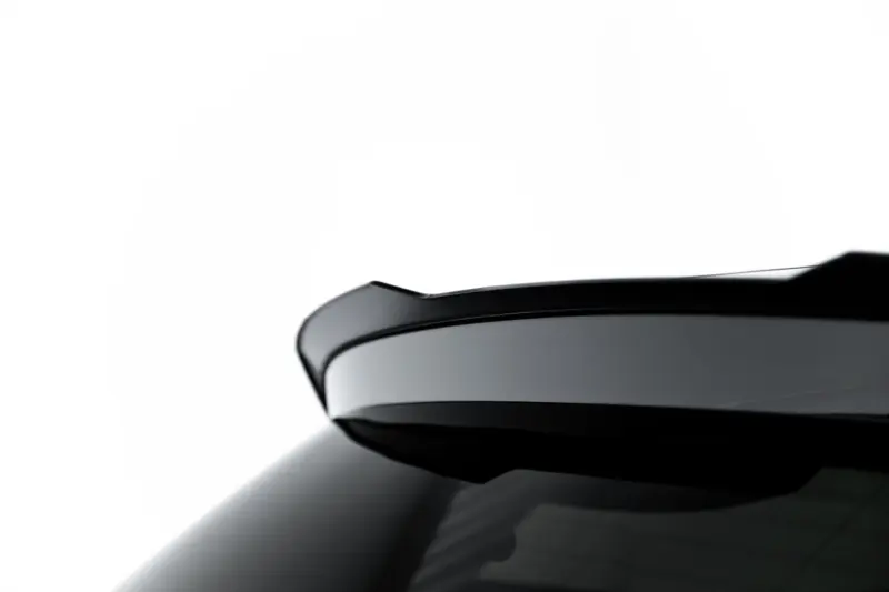 Close-up of a glossy black car body with smooth curved edges and reflected light.