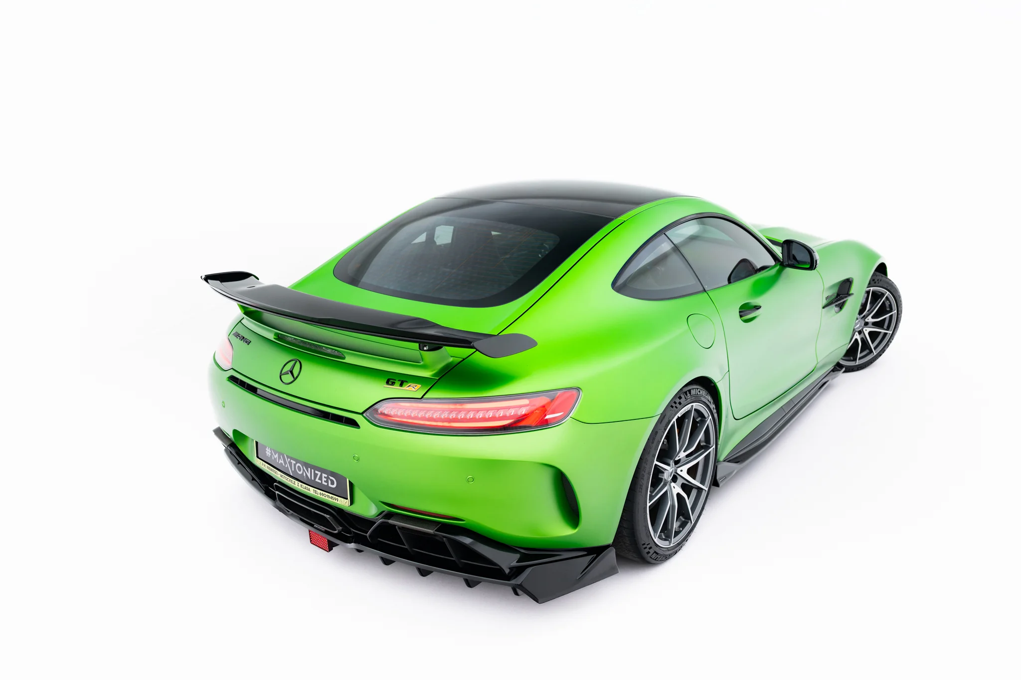 pol_po_Spoiler-Cap-Mercedes-AMG-GT-R-C190-Facelift-23891_4webp - OPSHOLDERS Rear-left view of a bright green Mercedes-AMG GT R with a black roof and carbon spoiler near the trunk.