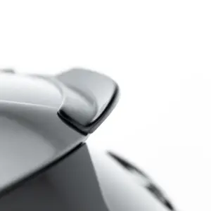 Close-up of a polished silver metal surface with smooth curves against a white background.