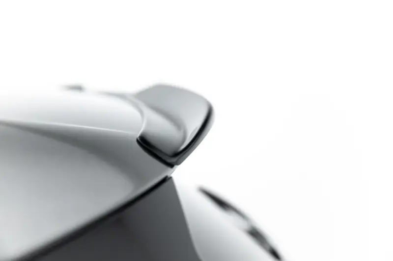 Close-up of a polished silver metal surface with smooth curves against a white background.