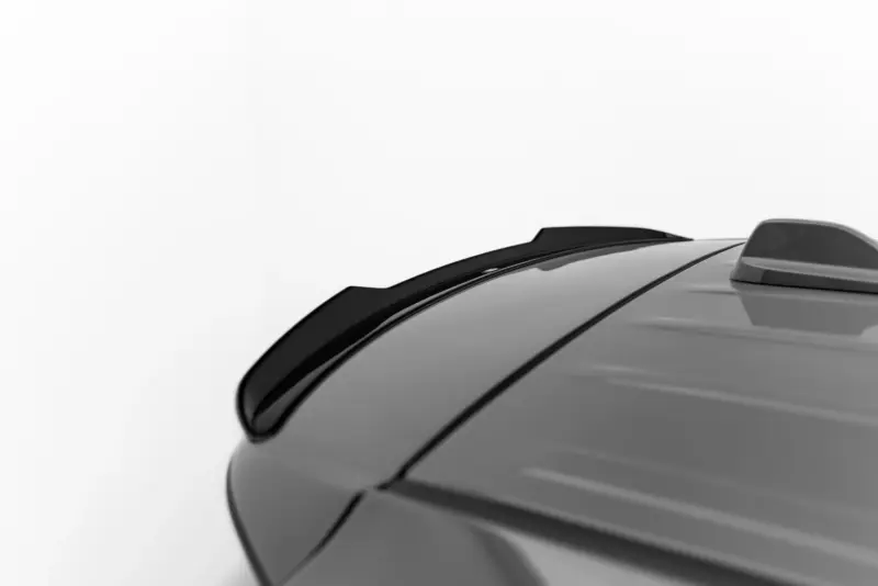 Close-up of a gray car roof with a black shark-fin antenna and roof seam running along the top.