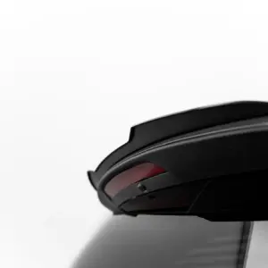 Close-up of a glossy black helmet with a curved visor against a white background.