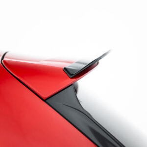 Close-up of a glossy red car body with a black trailing edge and spoiler detail.