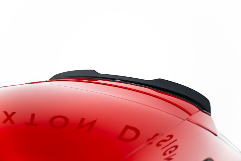 Close-up of a red glossy curved surface with a black trim along the top, against a white background (likely part of a vehicle).