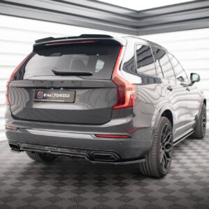 Rear view of a dark gray Volvo SUV in a bright studio, showcasing vertical taillights and a license plate reading '#MAXTONIZED'.