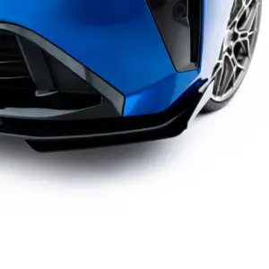 Close-up of a blue car's front end, showing the bumper, sharp body lines, and part of the alloy wheel.