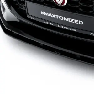Close-up of a black Jaguar car front with a plate that reads #MAXTONIZED and small Jaguar branding below it.