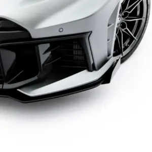 Close-up of a gray sports car’s front bumper with a black grille and GR badge visible on the left.