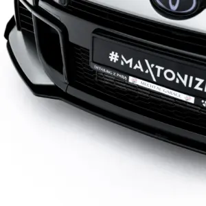 Close-up of a black car's front end featuring a custom license plate reading '#MAXTONIZED'