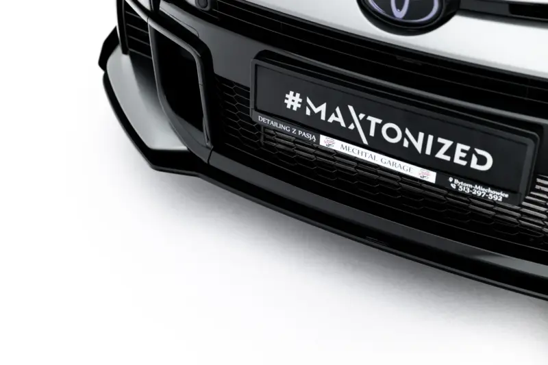 Close-up of a black car's front end featuring a custom license plate reading '#MAXTONIZED'
