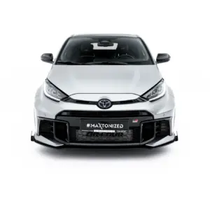 Front view of a silver Toyota car with a black grille, warning lights, and prominent bumper against a white background (vehicle centered).