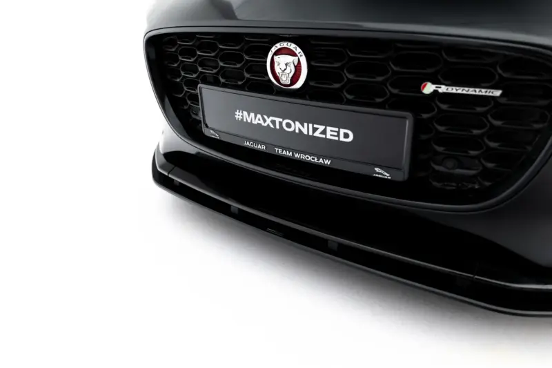 Front view of a black Jaguar with a honeycomb grille and emblem, displaying the #MAXTONIZED plate in the center stain of the bumper area.