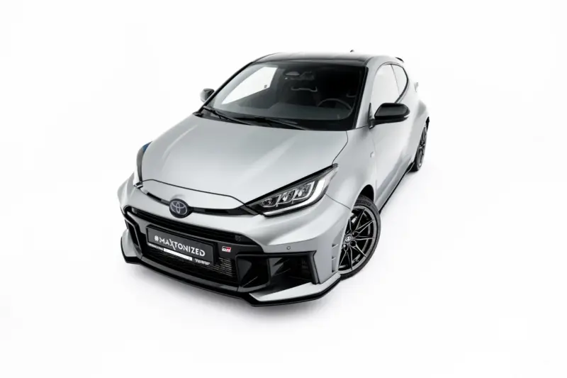 Front three-quarter view of a white sports hatchback with a black roof and large alloy wheels, featuring #MAXTONIZED on the bumper plate area.