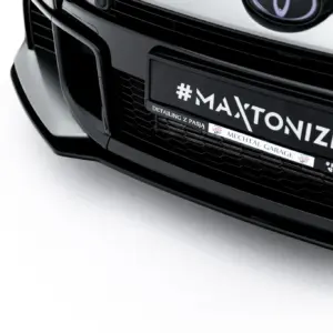 Close-up of a black car front showing a license plate that reads #MAXTONIZED with small branding text beneath.