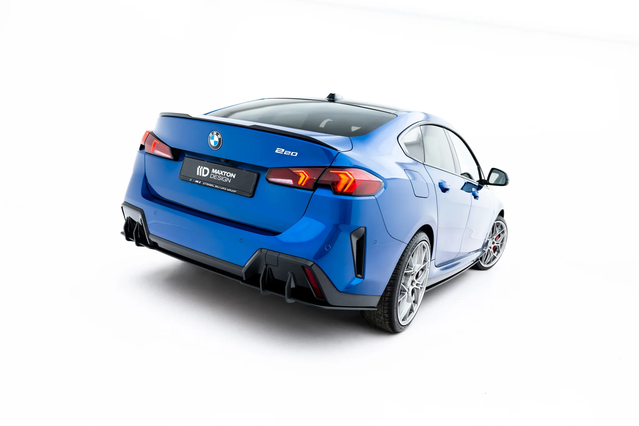 pol_po_Street-Pro-Rear-Diffuser-BMW-2-M-Pack-Gran-Coupe-F74-23845_2webp - OPSHOLDERS Blue BMW 220 shown from the rear-left angle, featuring a dark rear diffuser and prominent taillights against a white studio backdrop.