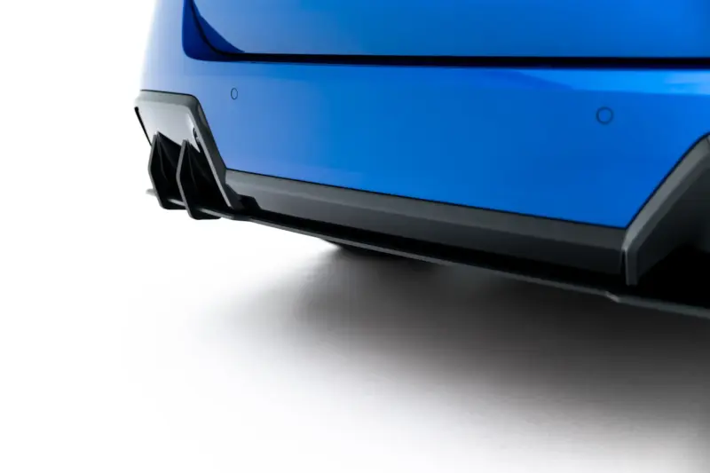 Close-up of a blue car’s front bumper with a black splitter and aerodynamic fins.