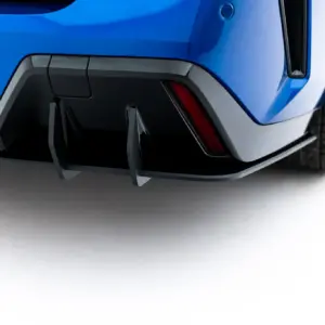 Close-up of the rear lower section of a blue car, showing a dark gray diffuser and part of the rear wheel.