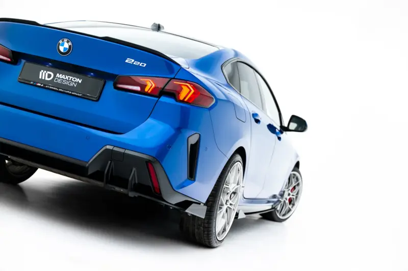 pol_po_Street-Pro-Rear-Diffuser-Flaps-BMW-2-M-Pack-Gran-Coupe-F74-23850_5webp - OPSHOLDERS Blue BMW car rear with taillights, badge, and Maxton Design plate visible, angled against a white background.