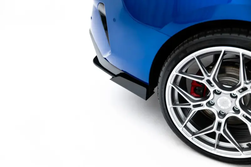 pol_po_Street-Pro-Rear-Diffuser-Flaps-BMW-2-M-Pack-Gran-Coupe-F74-23850_8webp - OPSHOLDERS Close-up of a blue car's front fender and alloy wheel with a red brake caliper against a white background