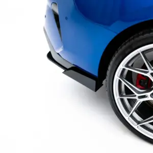 Close-up of a blue car's front fender and a large silver alloy wheel with visible brake caliper and tire.