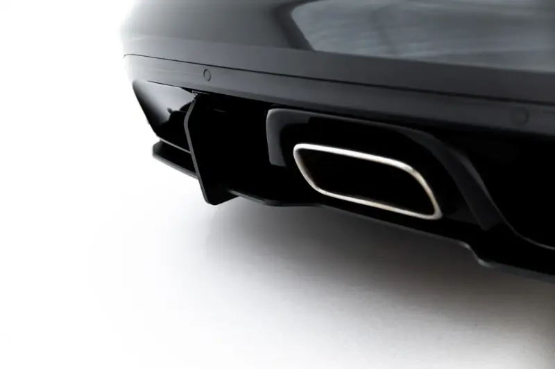 Close-up of a black glossy car rear showing the exhaust tip and bumper detail