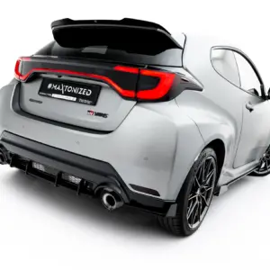 Rear three-quarter view of a white sports hatch with a large black spoiler and red taillights