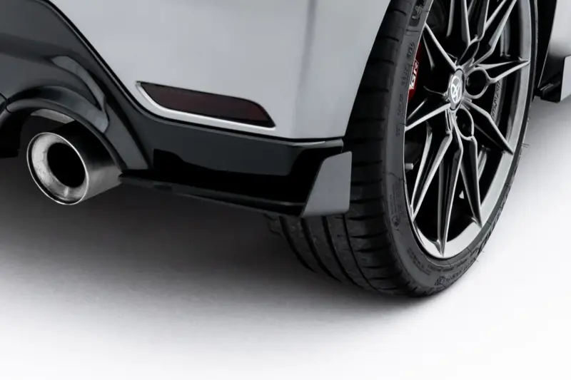 Close-up of a car rear wheel with a multi-spoke alloy rim and visible exhaust.