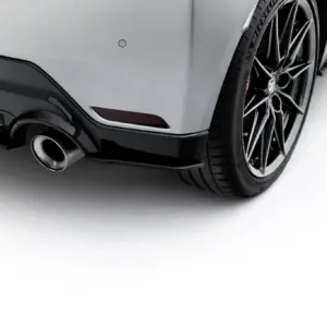 Close-up of a silver sports car's rear wheel, tire, exhaust, and lower bumper.