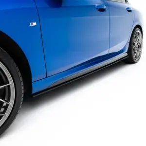 Close-up of a blue car's side, highlighting the wheel and M badge on the door