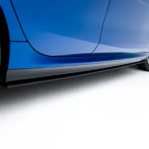 Close-up of a blue sports car's side panel and alloy wheel from a low angle with red brake calipers visible behind the rim