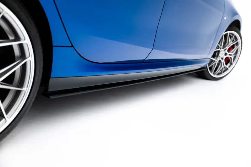 pol_po_Street-Pro-Side-Skirts-Diffusers-BMW-2-M-Pack-M235i-Gran-Coupe-F74-23841_3webp - OPSHOLDERS Close-up of a blue sports car's side panel and alloy wheel from a low angle with red brake calipers visible behind the rim