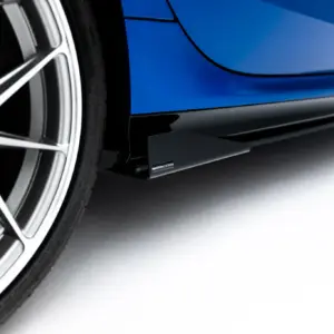 Close-up of a blue car showing its alloy wheel and lower body panel with a glossy finish.