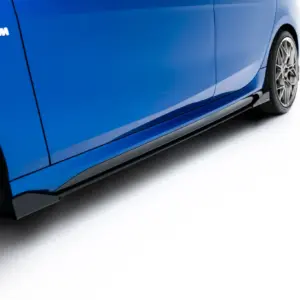 Side view of a blue BMW car showing the M badge and alloy wheel (close-up).