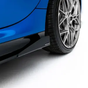 Close-up of a blue car body next to a large alloy wheel with a low-profile tire, seen from the side.