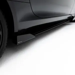 Close-up of a black car's lower side panel with a Maxton Design rocker accessory attached, wheel visible on the left.