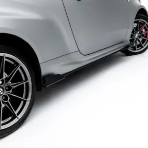 Close-up of a silver car side panel and an alloy wheel with a red brake caliper visible behind the spokes.