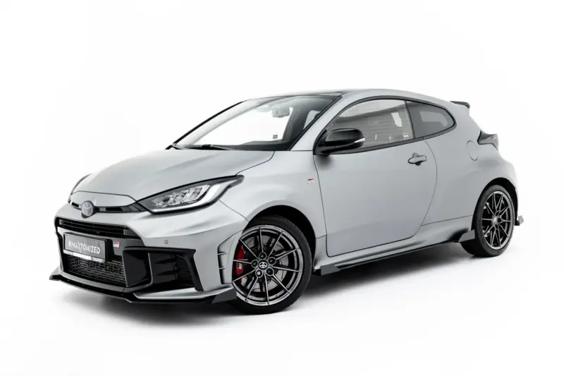 Grey sports hatchback car shown from the front-left, with prominent grille and alloy wheels on a white background (GR badge visible).