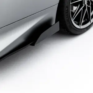 Close-up of a car's side panel and wheel, showing a gray body and black alloy wheel on the right.