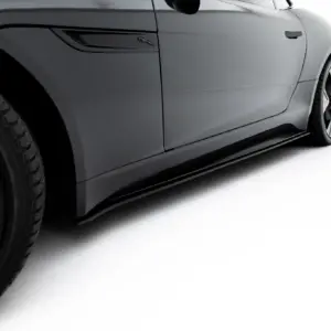 Close-up of a gray Jaguar side panel with badge and visible wheel rim on the left.