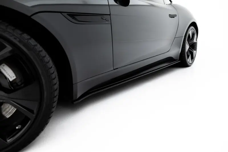Close-up of a gray Jaguar side panel with badge and visible wheel rim on the left.