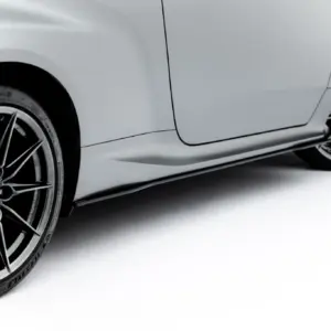 Close-up of a grey car showing front wheel with black alloy rim, red brake caliper, and tire treads visible.