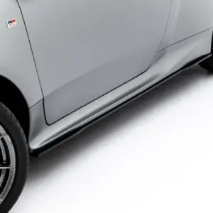 Close-up of a gray car door and wheel, with a red/gray GR badge visible on the side panel and stylish alloy rims