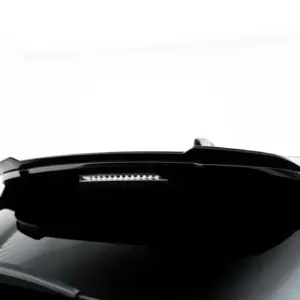 Partial close-up of a white car's front end, showing a black hood and windshield area with a slim light strip beneath the windshield.