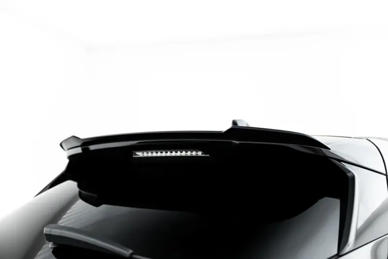 Partial close-up of a white car's front end, showing a black hood and windshield area with a slim light strip beneath the windshield.