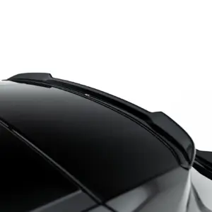 Close-up of a glossy black car roof and rear spoiler with reflections on the surface against a white background.